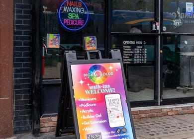 Front view of Pick A Color Studio, New York, welcoming with spa services board and neon signs.