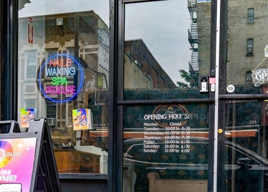 Entrance to Pick A Color Studio, a nail salon in New York, New York, US, featuring colorful signage and business hours.