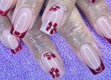 Elegant red-tipped nails with floral accents at Lady Nails, Taupō, Waikato, NZ.
