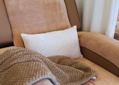 Comfortable therapy chair at Oaken, Singapore, SG with soft blanket and pillow for relaxation.