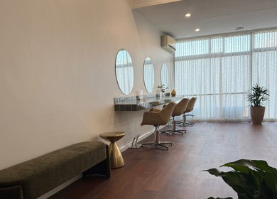 Modern salon interior at Jessi Do My Hair, Dee Why, New South Wales. Features stylish chairs and round mirrors.