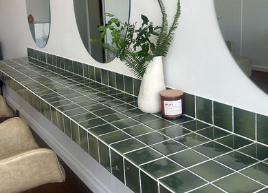 Elegant green tiled counter at Jessi Do My Hair in Dee Why, New South Wales, AU with chairs and decor.