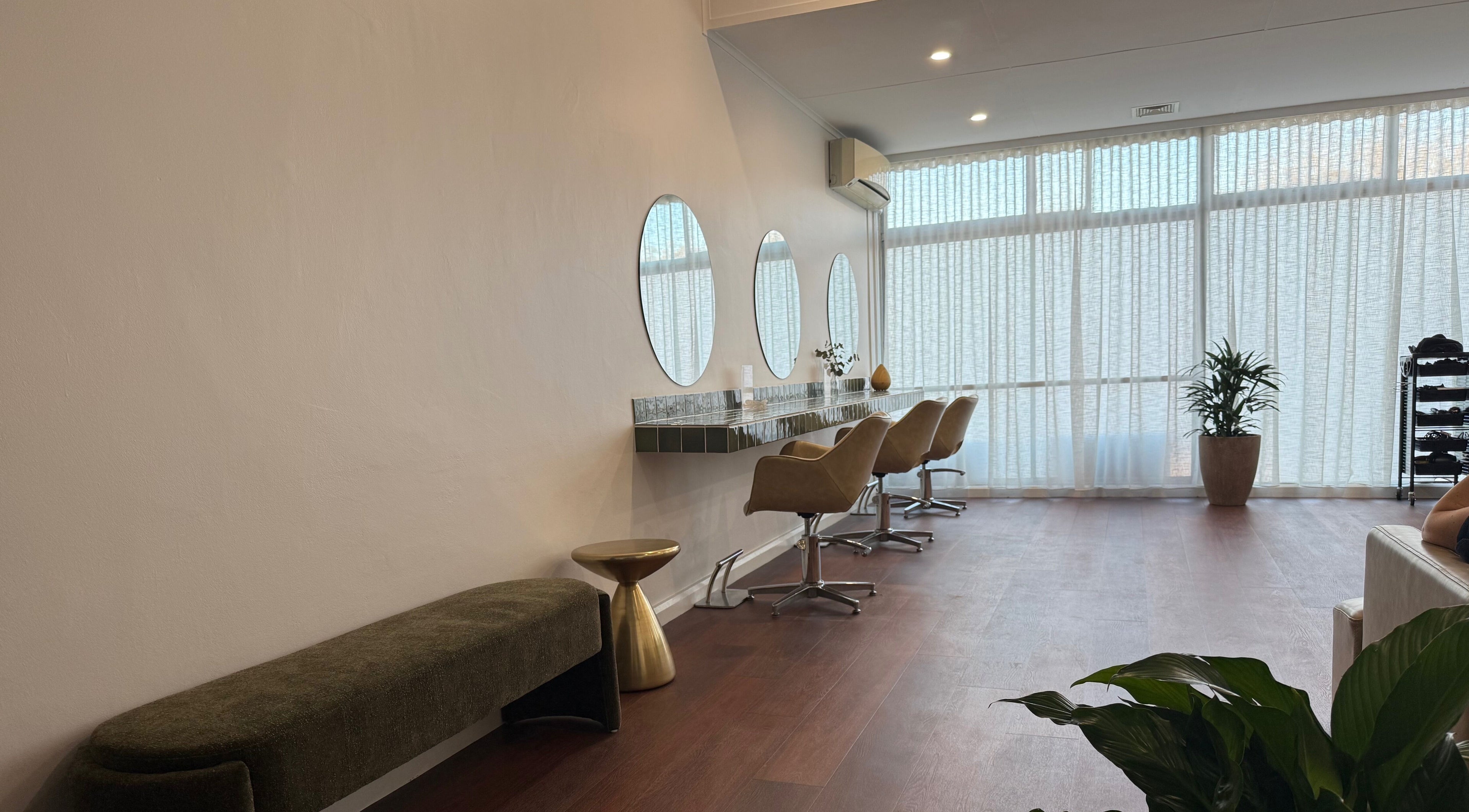 Contemporary salon at Jessi Do My Hair @ Cove Hair in Dee Why, New South Wales, AU with chic seating and mirrors.