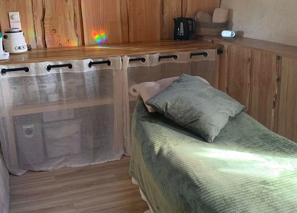 Salle de soins cosy au Louve Institut, Saint-pardoux-soutiers, Nouvelle-aquitaine, FR, avec lit de massage.
