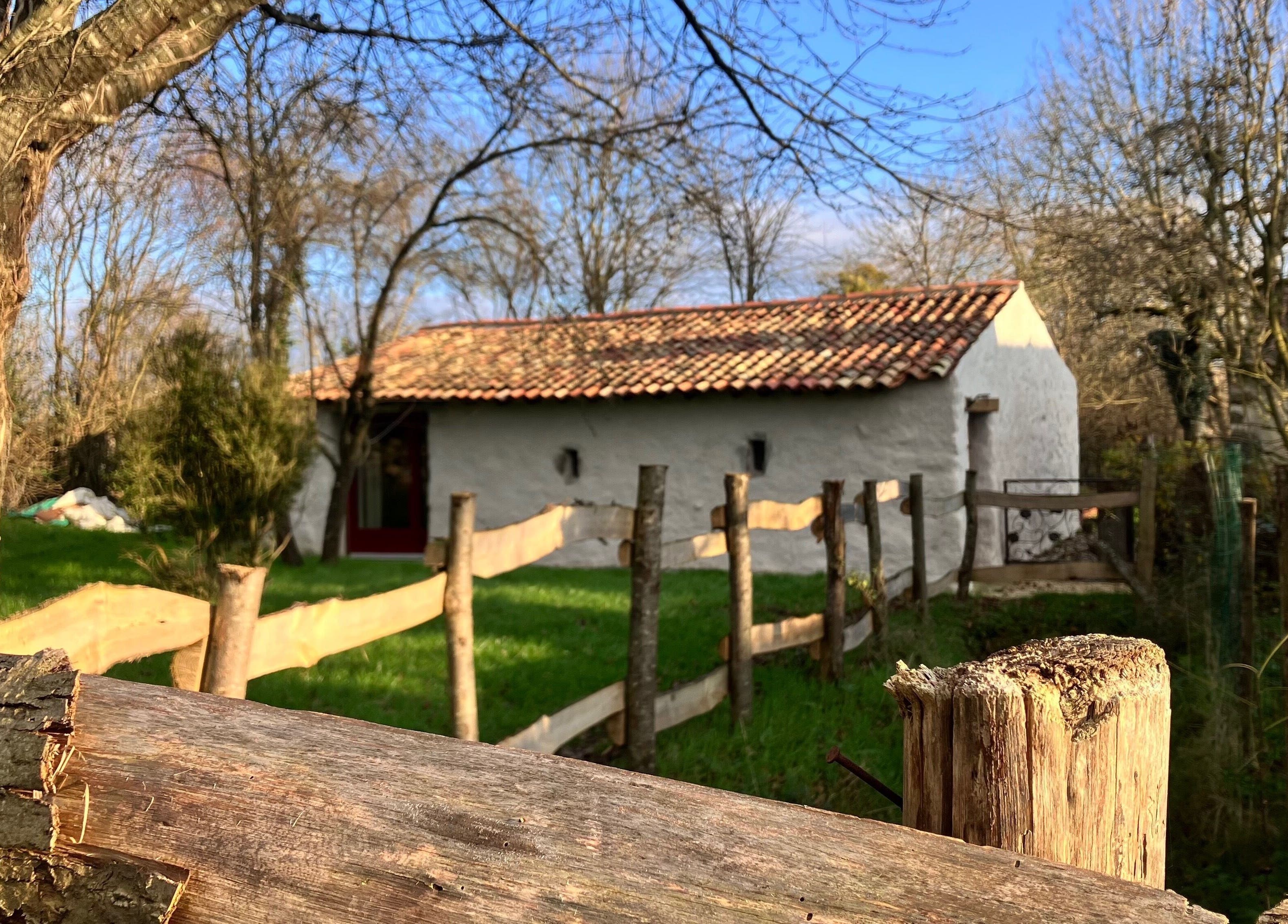 Bâtiment rustique à Louve Institut, Saint-Pardoux-Soutiers, Nouvelle-Aquitaine, FR, entouré d'arbres.