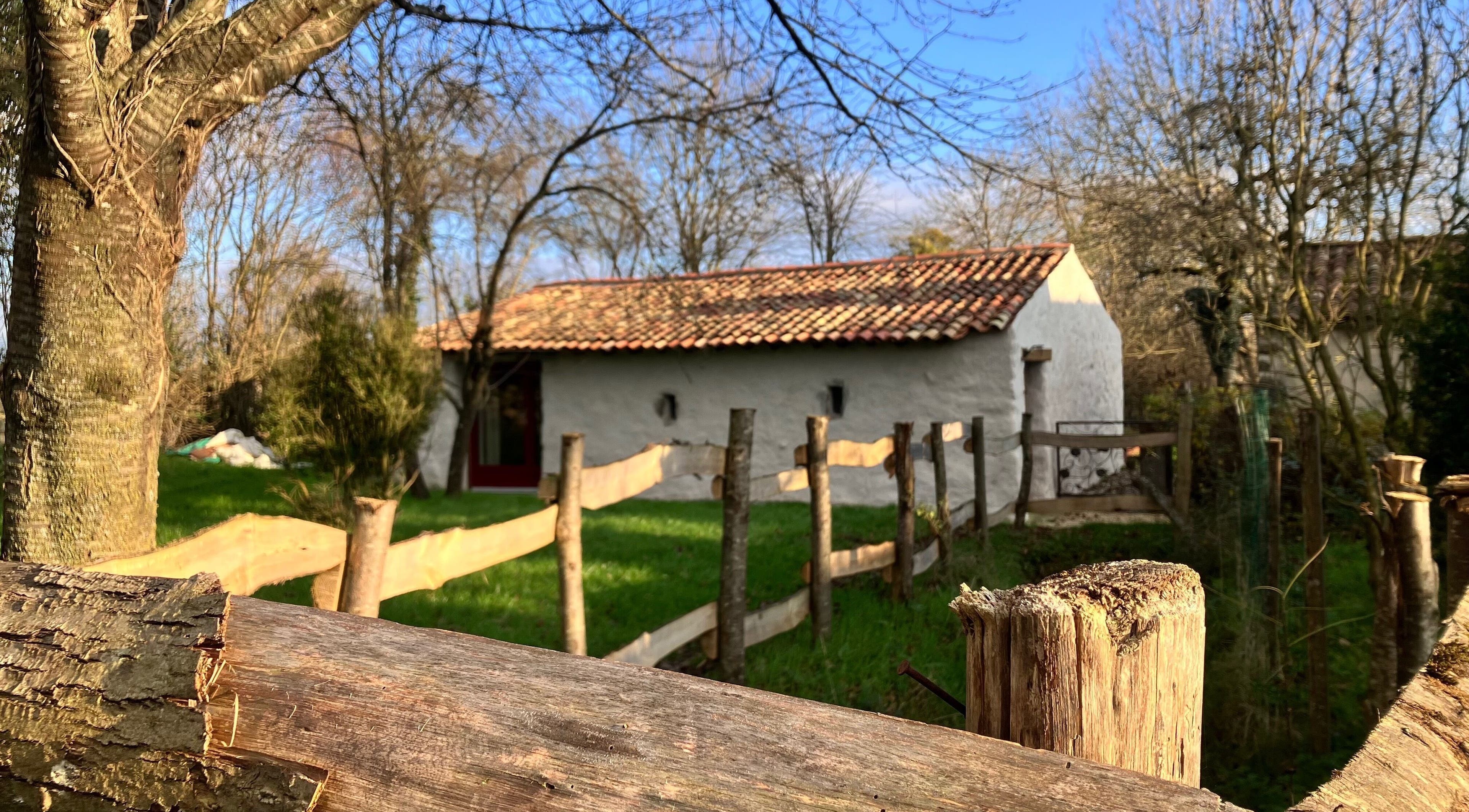 Bâtiment rustique à Louve Institut, Saint-Pardoux-Soutiers, Nouvelle-Aquitaine, FR, entouré d'arbres.