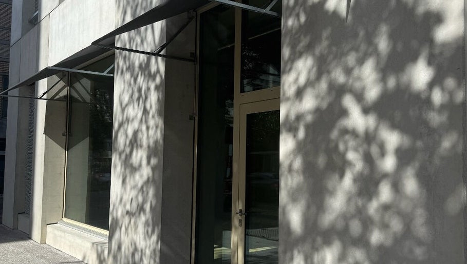 Eingang zu Fl in Zürich, Zürich, CH mit moderner Glasfassade und Schattenbildungen.