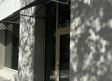 Eingang zu Fl in Zürich, Zürich, CH mit moderner Glasfassade und Schattenbildungen.