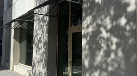 Eingang zu Fl in Zürich, Zürich, CH mit moderner Glasfassade und Schattenbildungen.