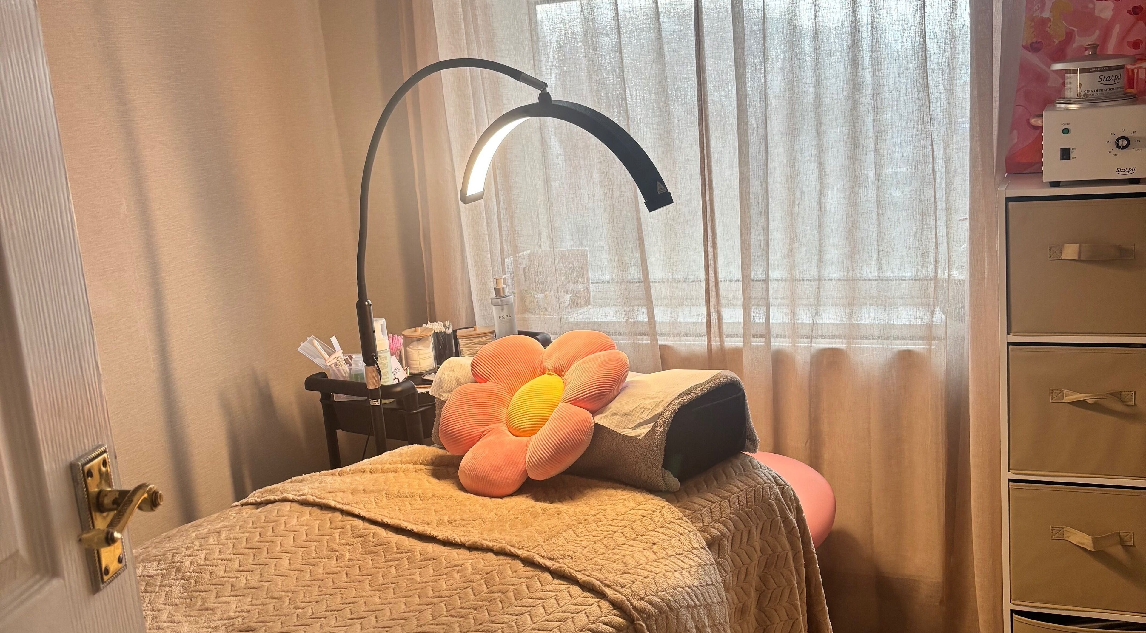 Cozy treatment room at Brows: By Hazel Bromiley in Chorley, England, with floral decor and soft lighting.