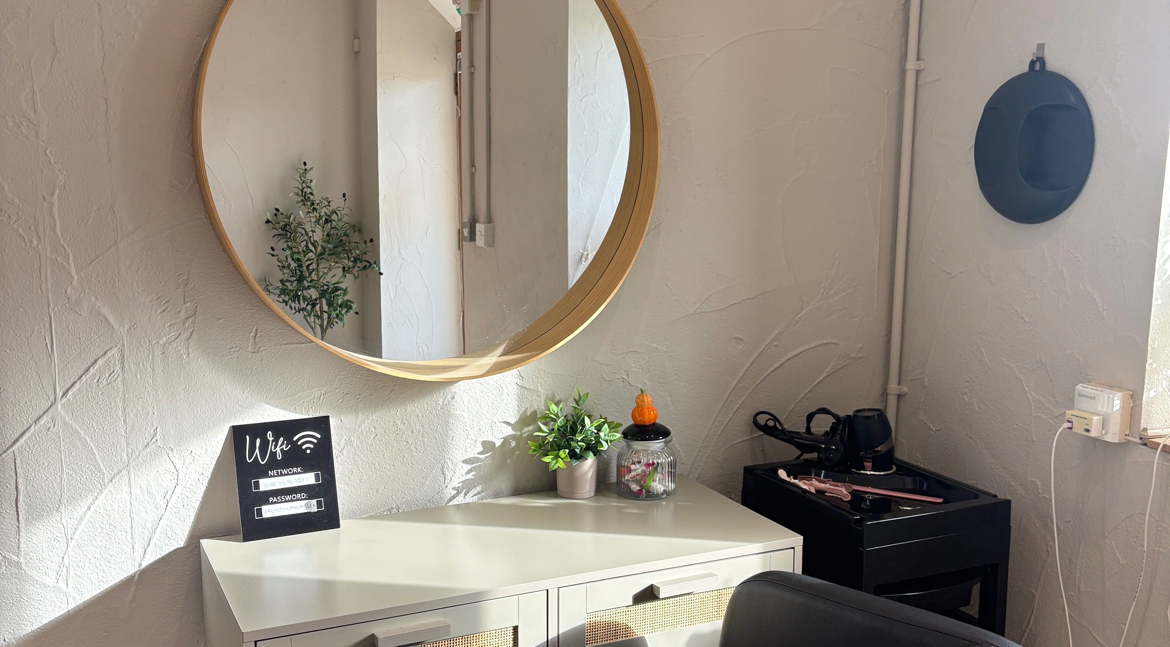Modern beauty salon at The Beauty Barn, Stalbridge, England, GB featuring a stylish round mirror and decor.