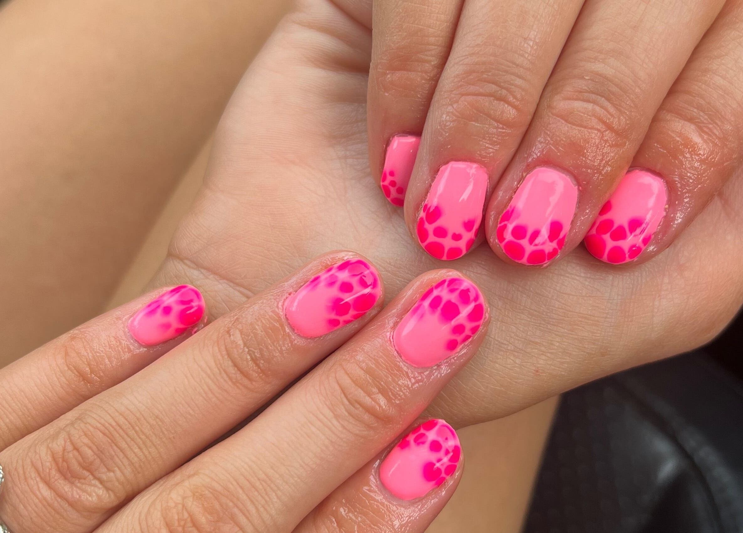 Bright pink nail art with vibrant patterns at The Nail Lounge by Poppie, Harrogate, England, GB.