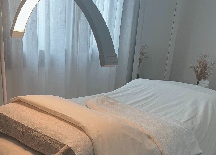 Salle de soin lumineuse et apaisante chez Hoanity, Pontoy, Grand Est, FR. Lit de massage prêt pour le soin.