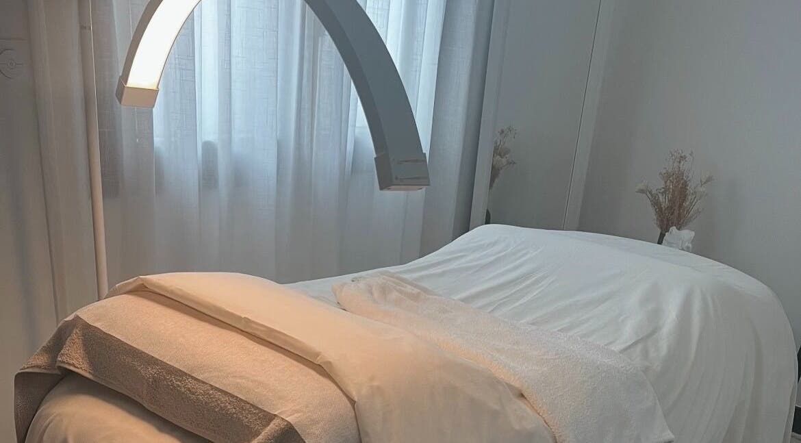Salle de soin lumineuse et apaisante chez Hoanity, Pontoy, Grand Est, FR. Lit de massage prêt pour le soin.