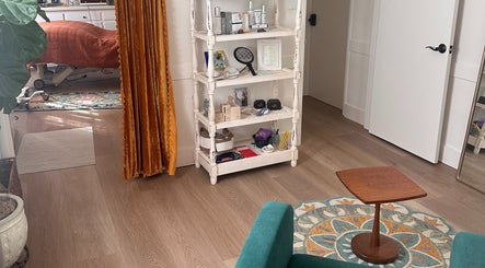 Cozy treatment room at Donna Cherie Aesthetics in Santa Cruz, California, US, with plush seating and beauty products.