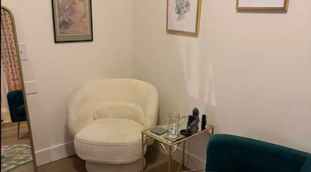 Elegant corner at Donna Cherie Aesthetics, Santa Cruz, California, US, featuring a cozy chair and decorative art.