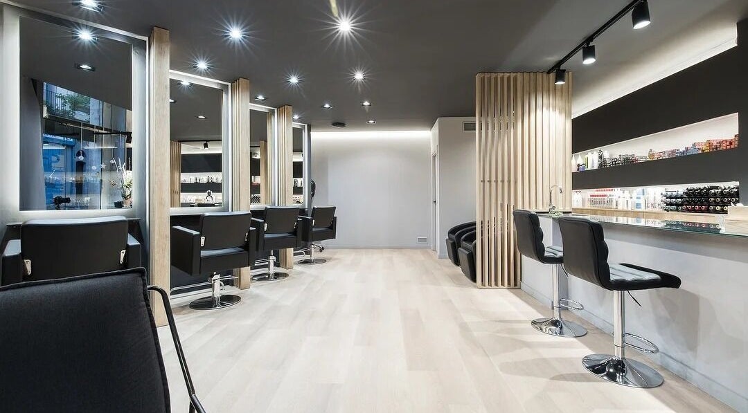 Interior moderno de Portada Estilistes, Mataró, Catalunya, ES, con sillas y tocadores elegantes.