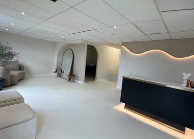 Glossed Clinic's modern lobby area in Sturry, England, GB, featuring elegant seating and soft lighting.
