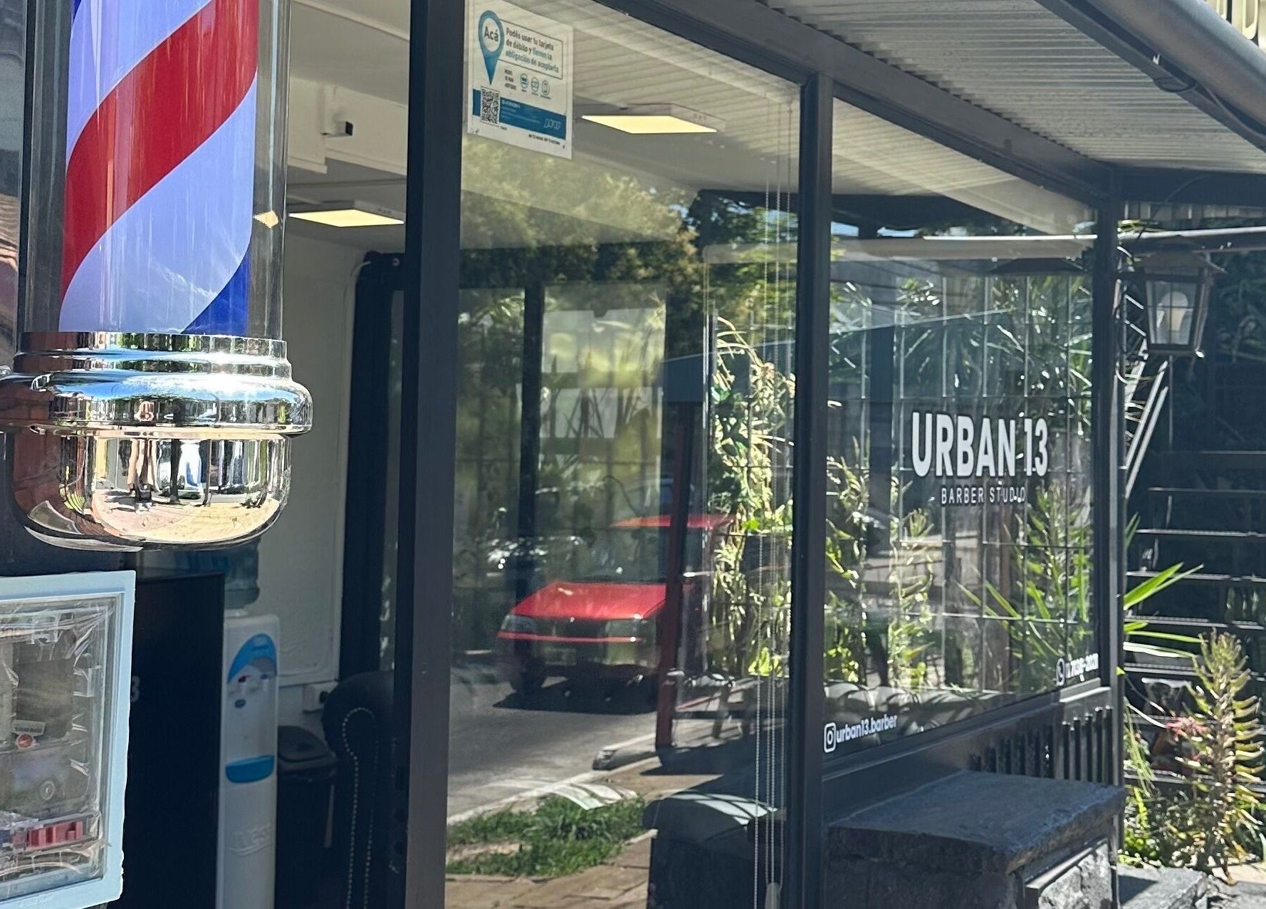 Entrada de Urban13 Barber Studio en Ramos Mejía, Provincia De Buenos Aires, AR, con poste tradicional de barbería.