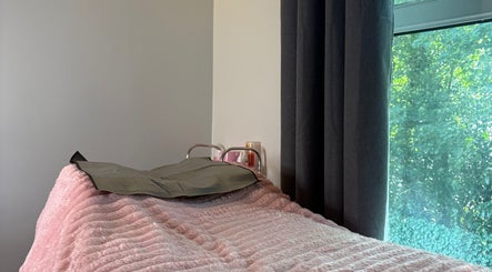 Cozy treatment bed with soft pink cover at Studio Samantha, Welwyn Garden City, England, GB.