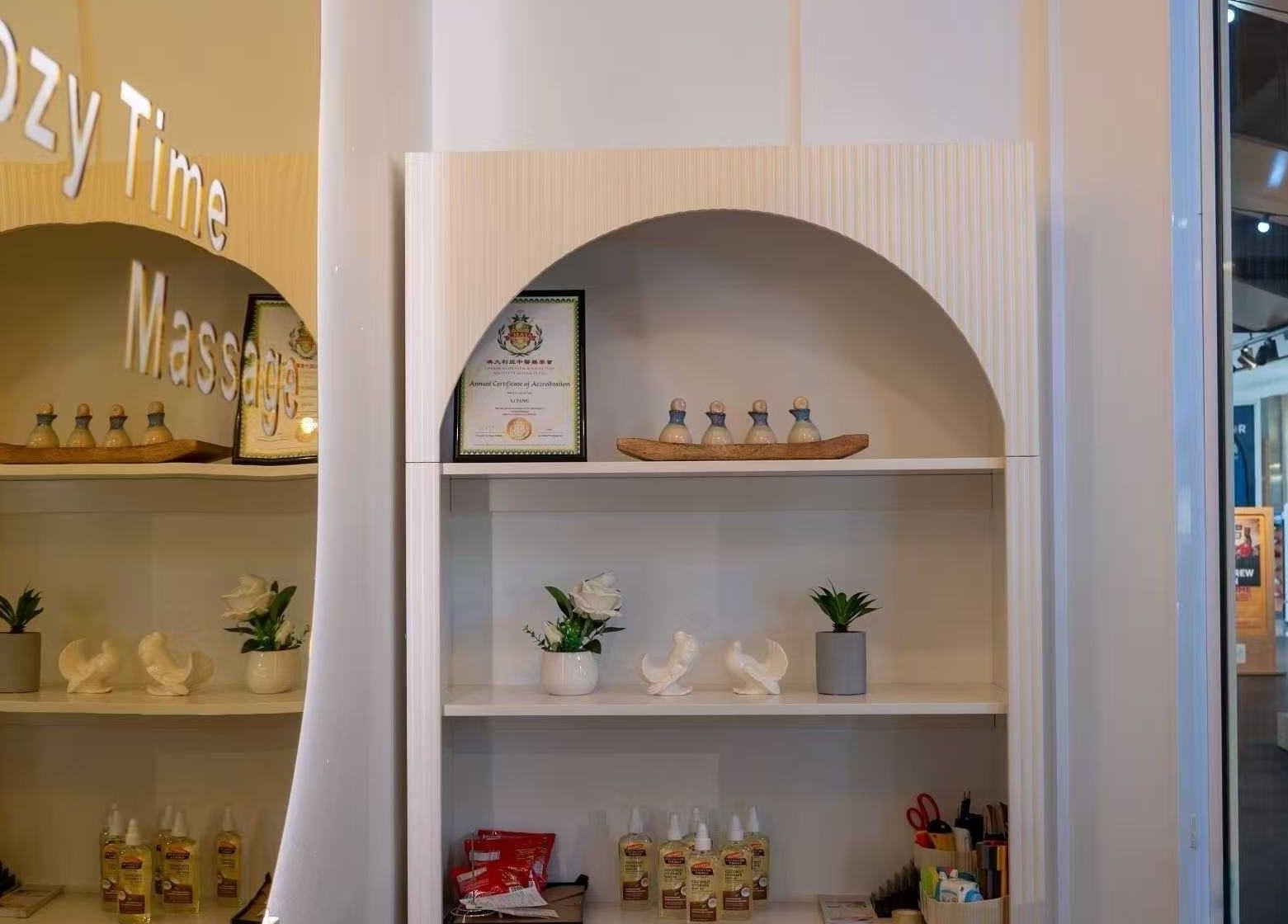 Elegant shelf in Cozy Time Massage, Coolangatta, Queensland, AU, featuring oils, decor, and certification.