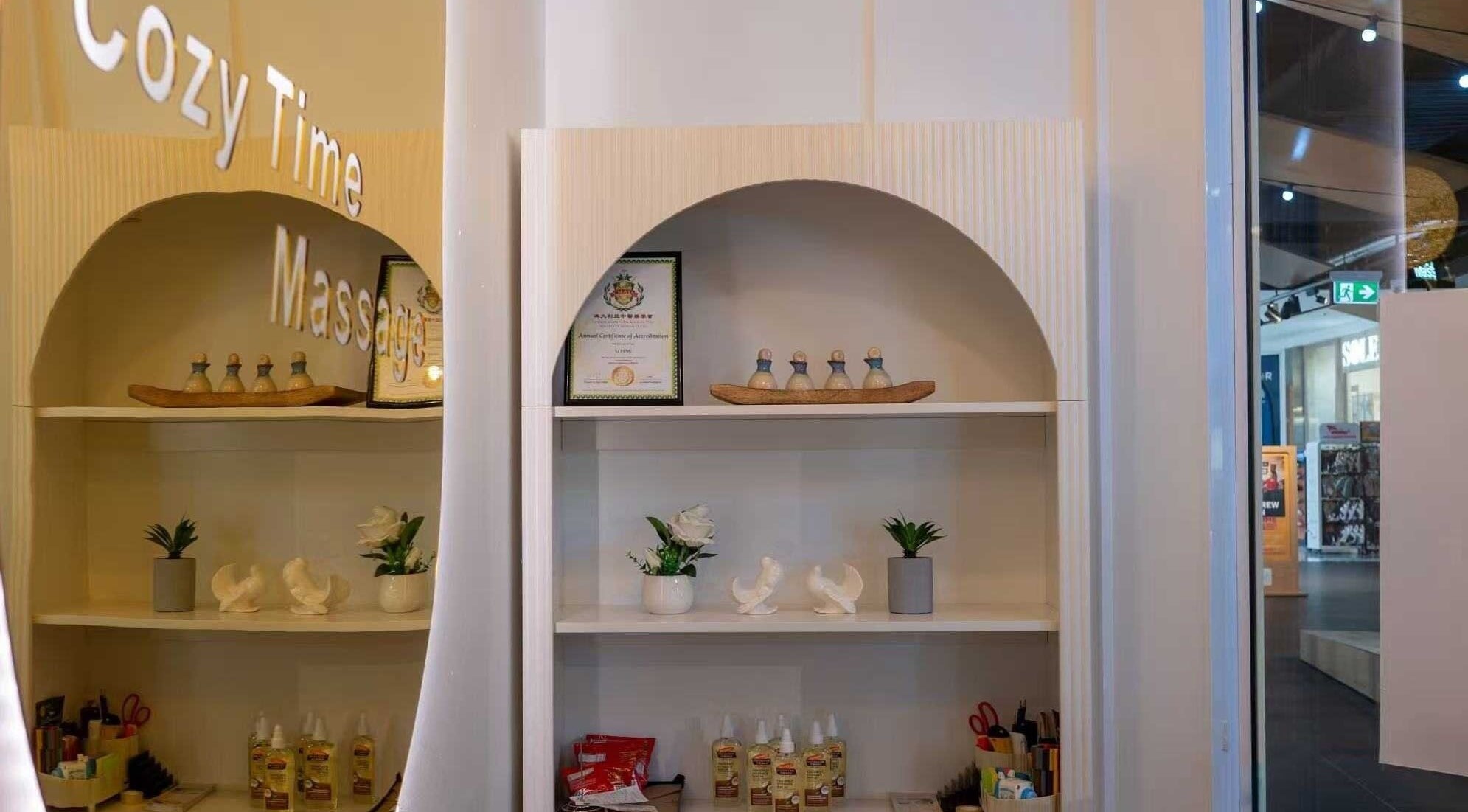Elegant shelf in Cozy Time Massage, Coolangatta, Queensland, AU, featuring oils, decor, and certification.