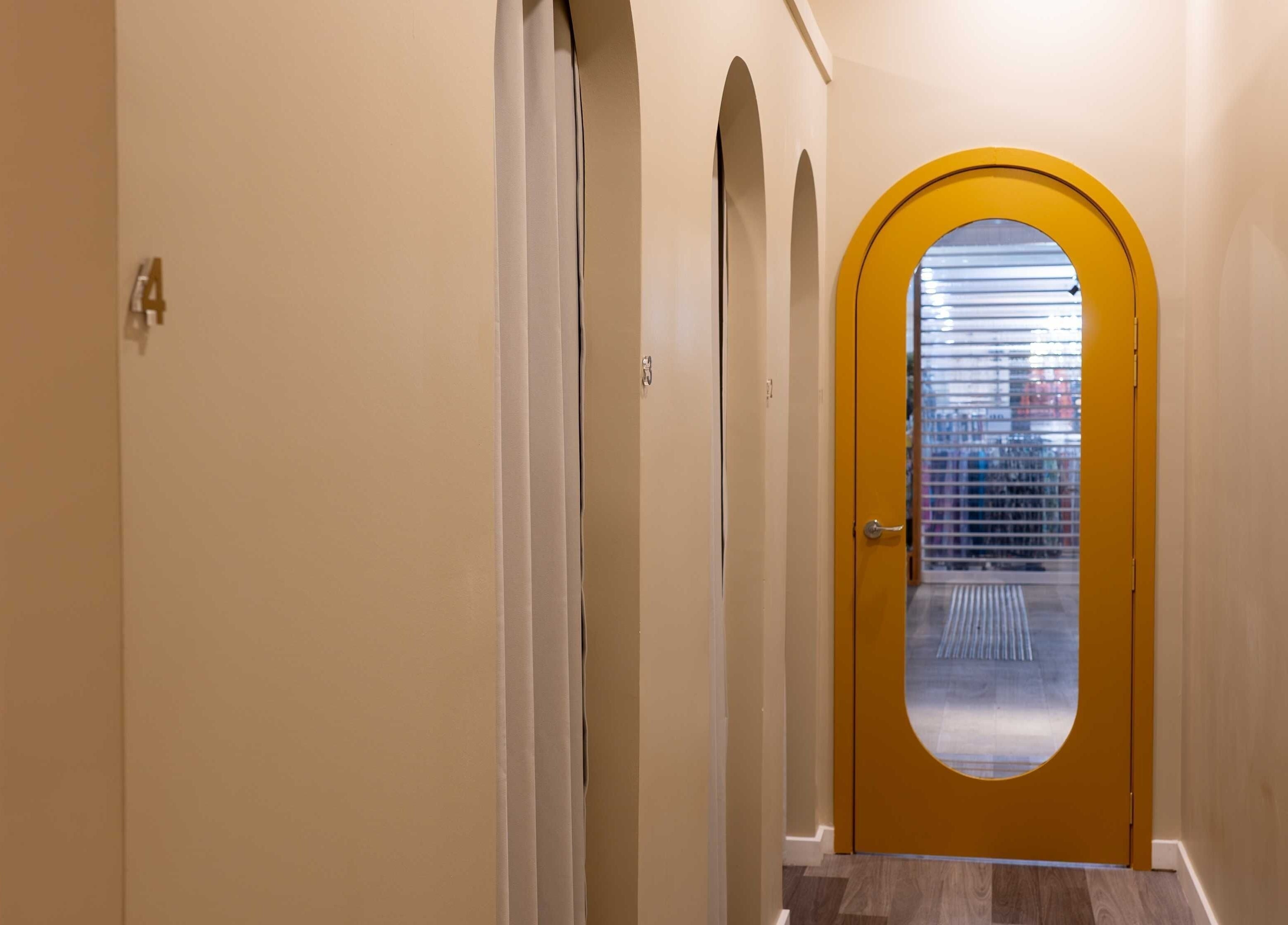 Chic hallway with yellow arched door at Cozy Time Massage in Coolangatta, Queensland, AU.