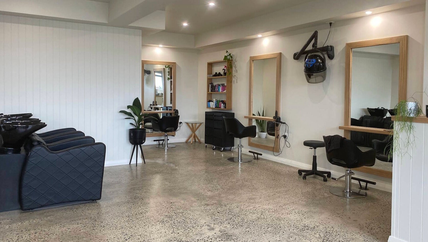 Modern interior of Beachcomber Hairsalon, Ulladulla, New South Wales, AU with salon chairs and mirrors.