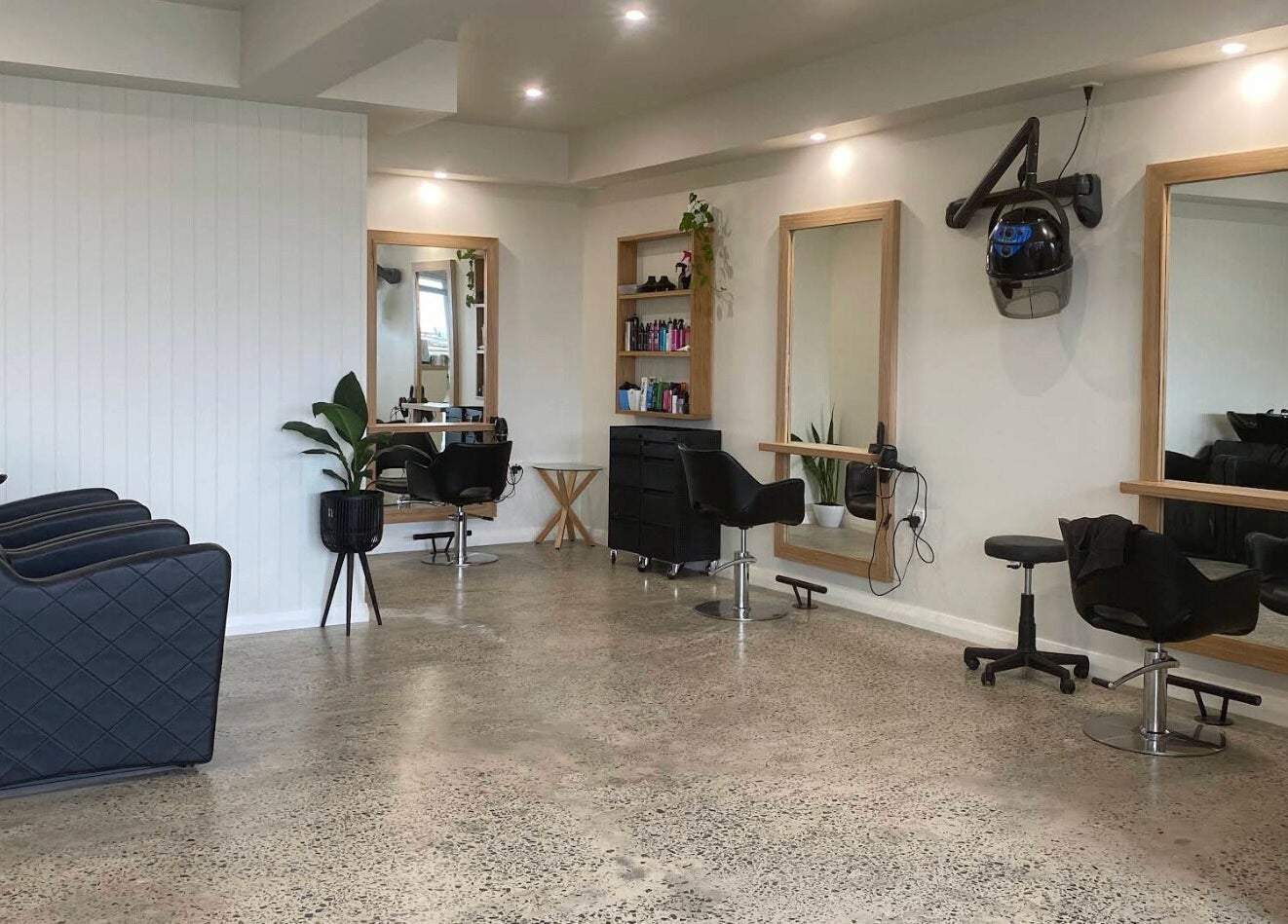 Modern interior of Beachcomber Hairsalon, Ulladulla, New South Wales, AU with salon chairs and mirrors.