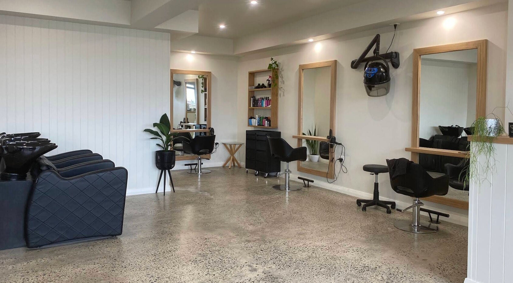 Modern interior of Beachcomber Hairsalon, Ulladulla, New South Wales, AU with salon chairs and mirrors.