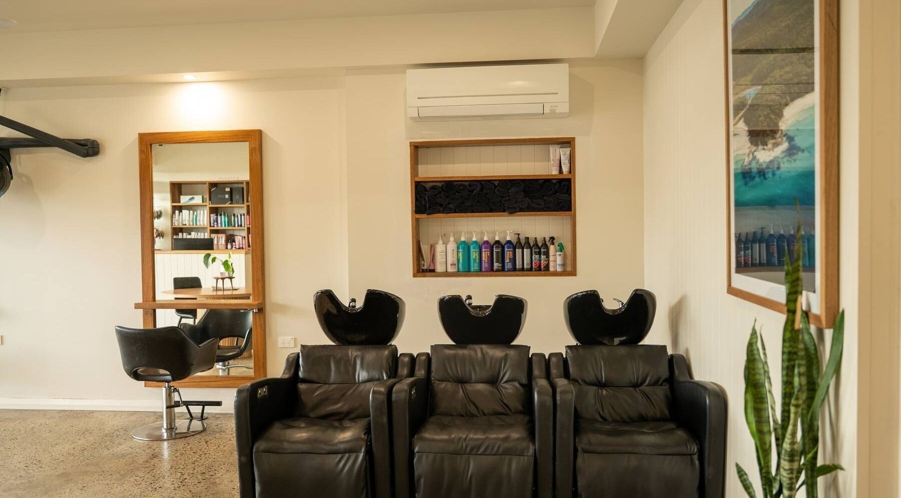 Modern interior of Beachcomber Hairsalon, Ulladulla with sleek wash stations and styling chair.