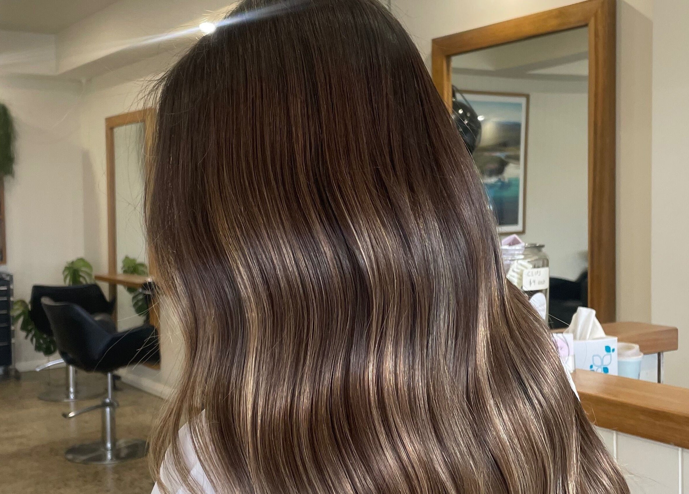 Luxurious silky brown waves at Beachcomber Hairsalon, Ulladulla, New South Wales, AU. Chic salon interior in view.