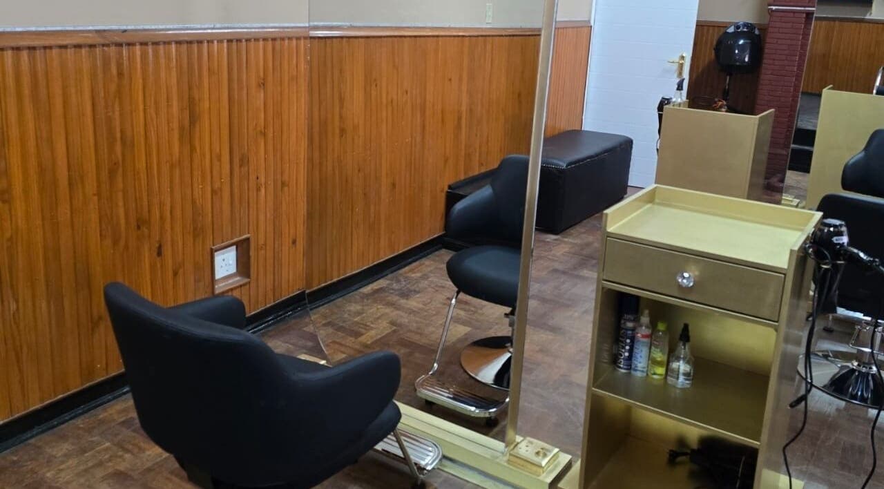 Modern salon interior at On The Edge Prostyling, Upington, Northern Cape, ZA, with sleek black chairs.