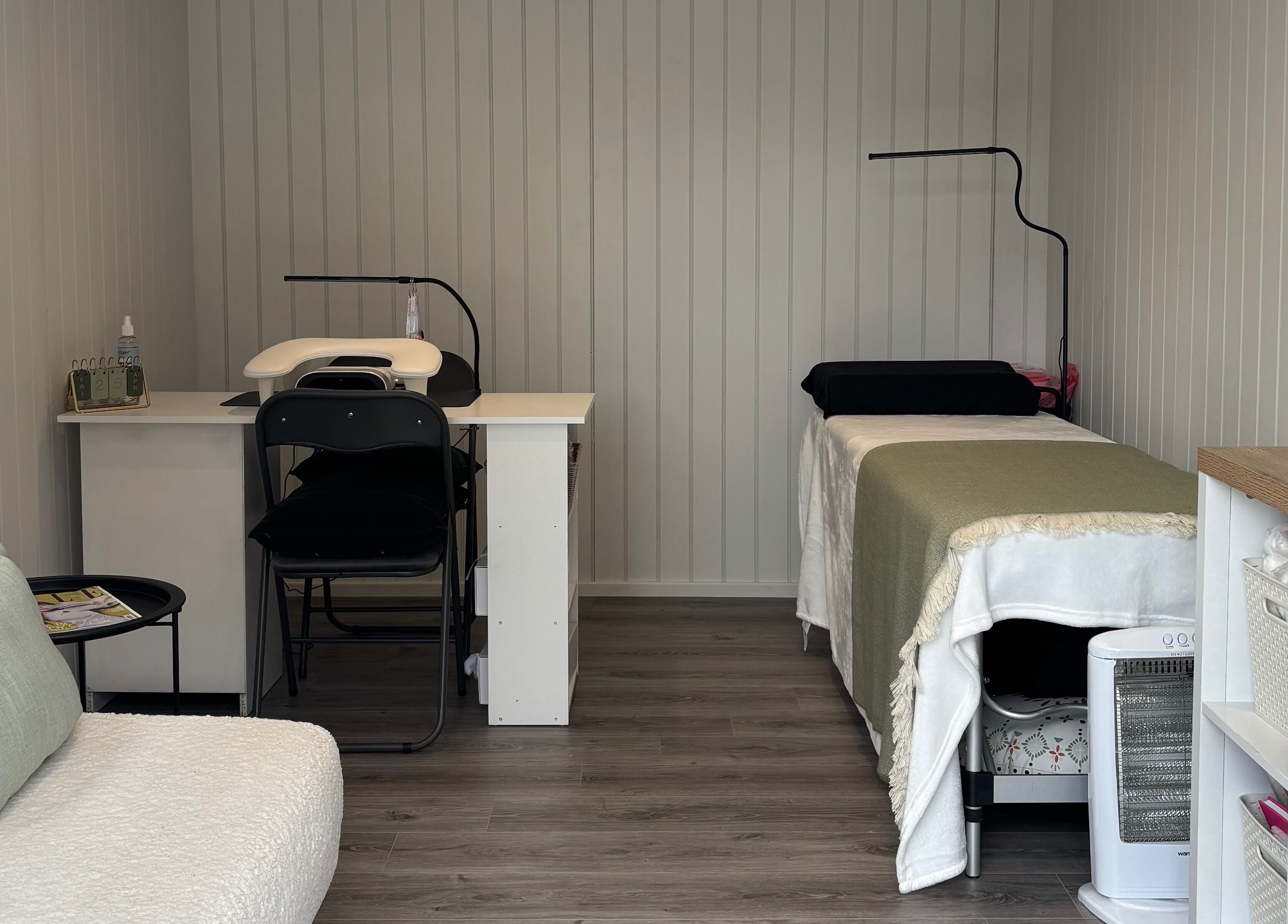 Cozy treatment room at The Beauty Cabin, Royal Leamington Spa, England, GB featuring a massage bed and seating area.