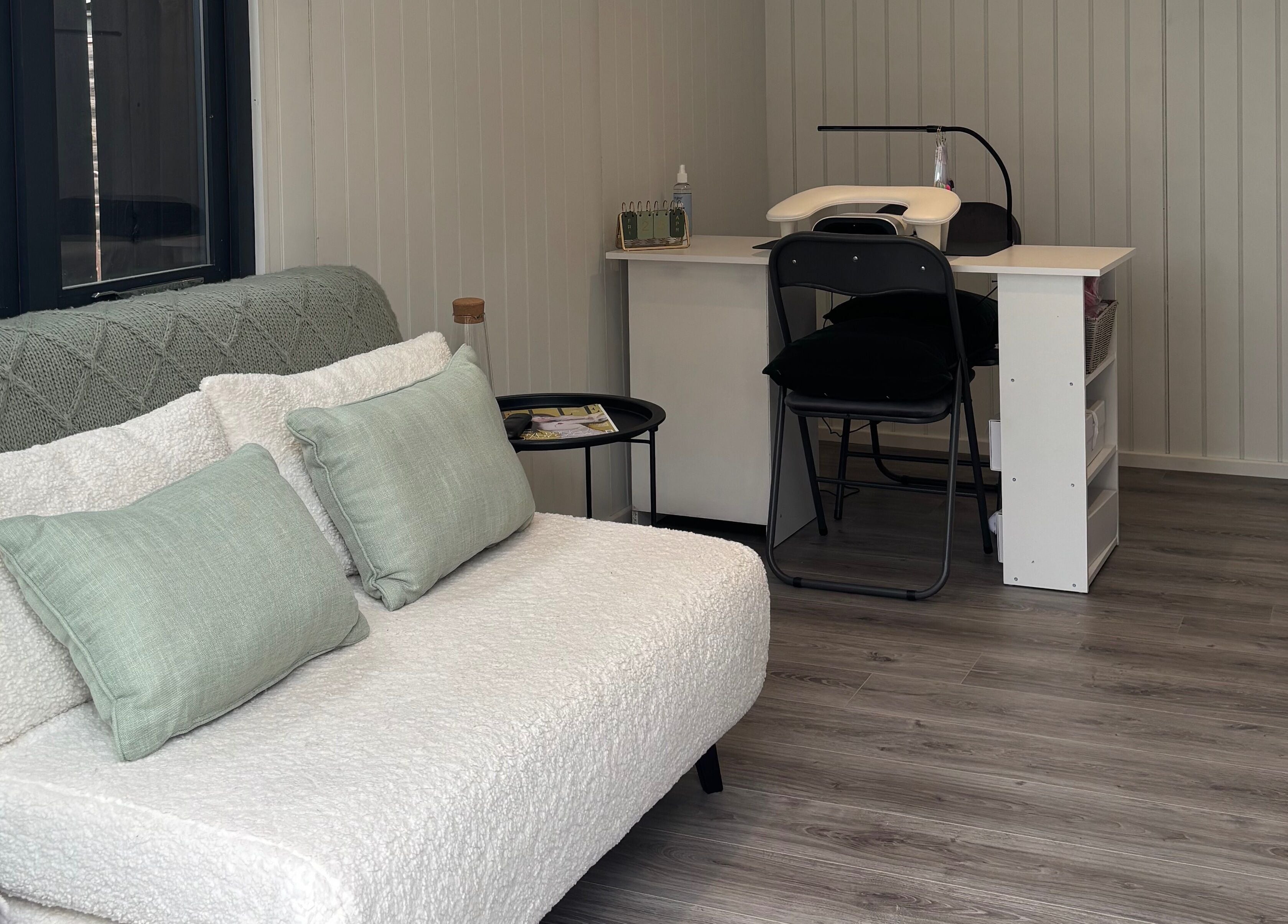 Cozy interior of The Beauty Cabin, Royal Leamington Spa, England, GB with plush seating and a manicure station.
