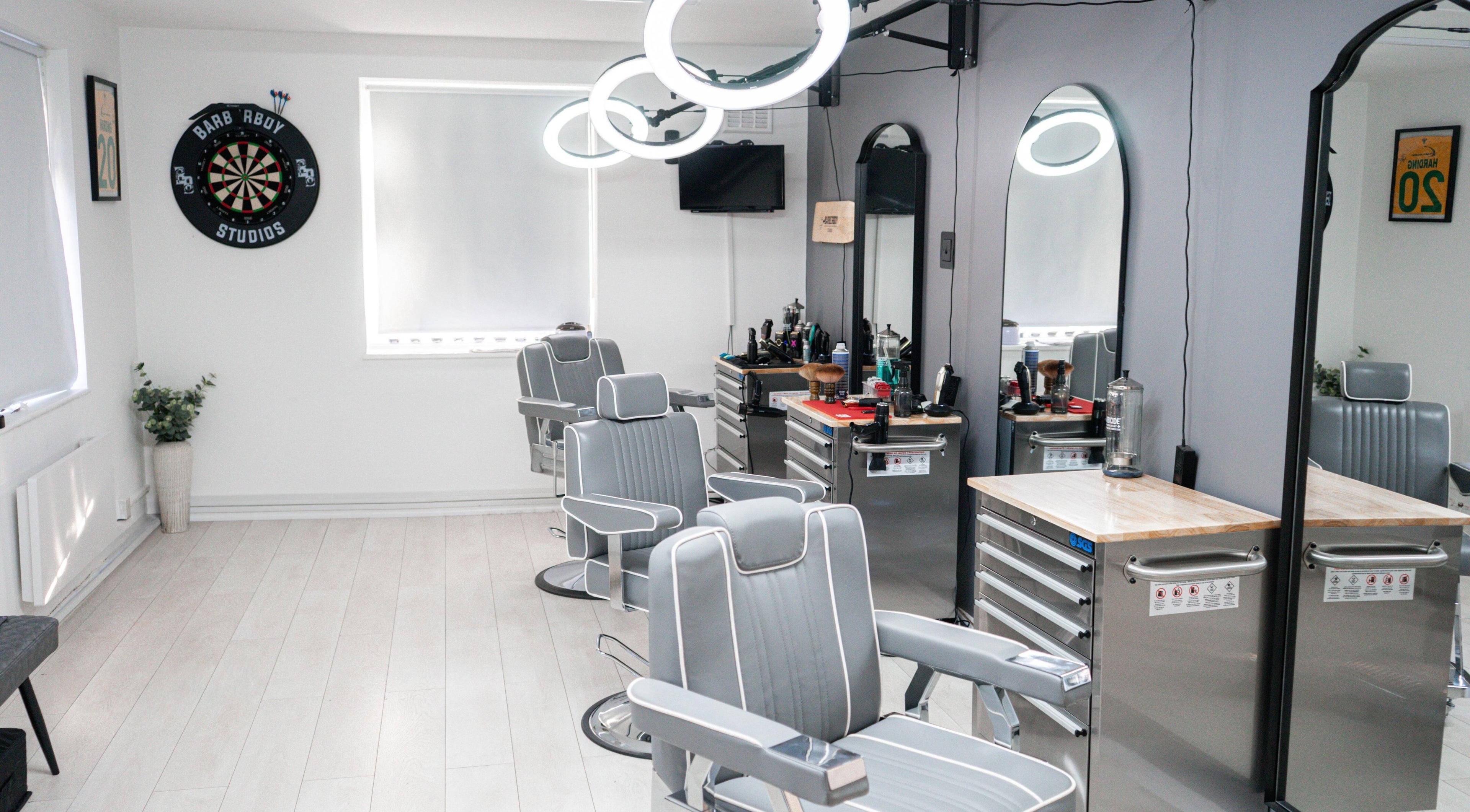 Modern interior of Barber Boy Studio with sleek chairs and mirrors in Horsham, England, GB.