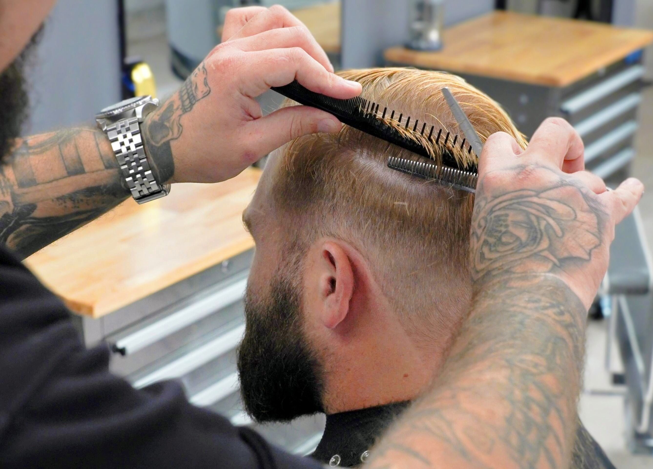 Stylist trimming a man's hair at Barber Boy Studio, Horsham, England, GB.