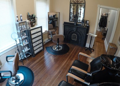 Elegant salon interior at Prodigo Day Spa & Salon, Harleysville, Pennsylvania, with stylist chairs and a fireplace.