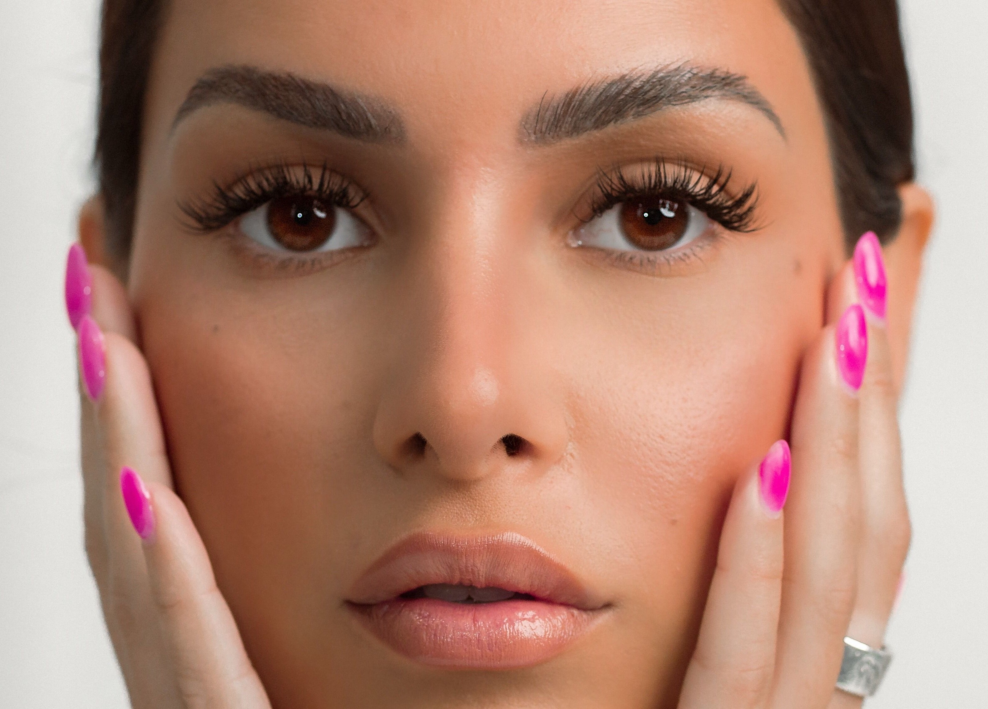Close-up of radiant face with vibrant nails at DAZEDEBEAU, Vaughan, Ontario, CA for beauty treatments.