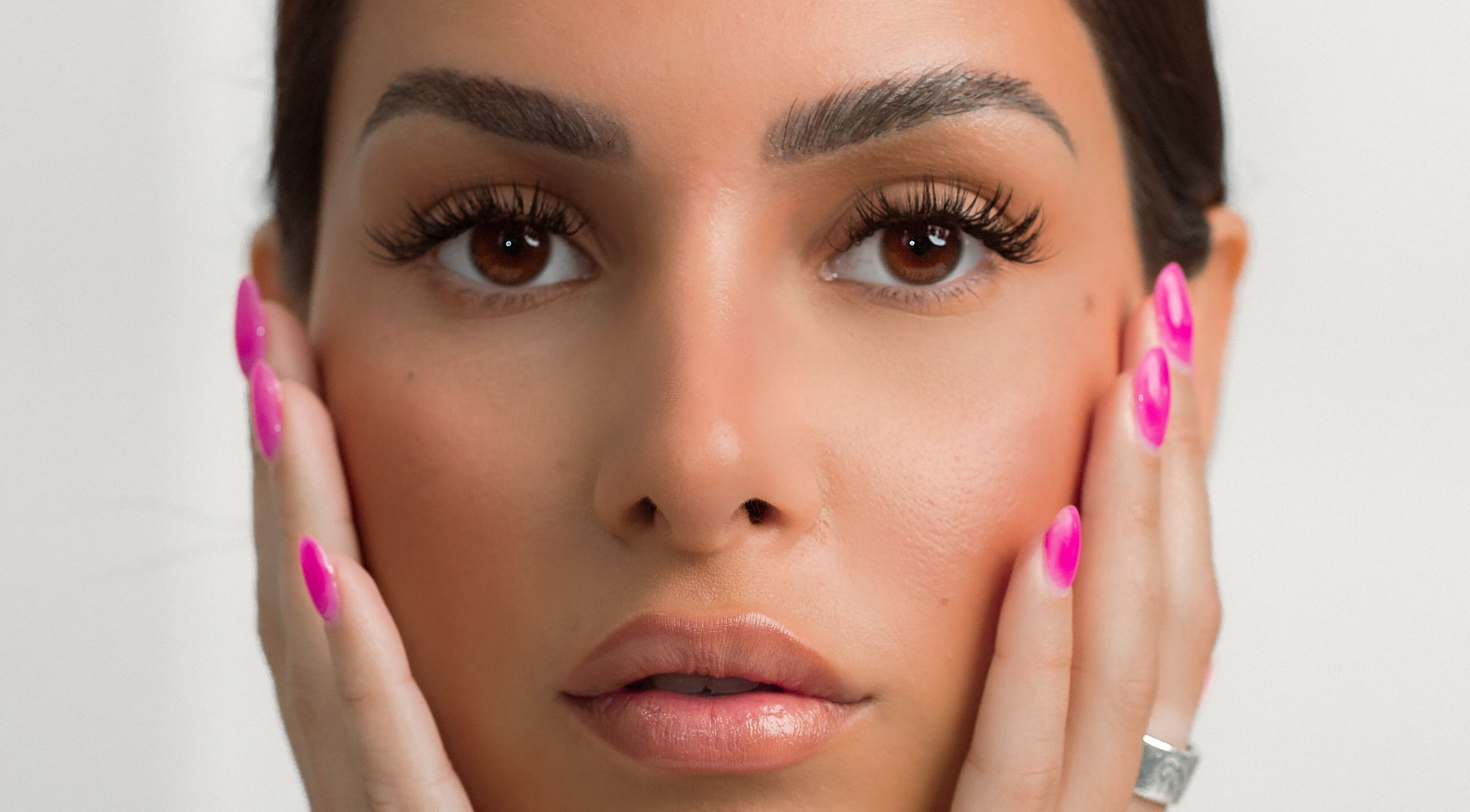 Close-up of radiant face with vibrant nails at DAZEDEBEAU, Vaughan, Ontario, CA for beauty treatments.