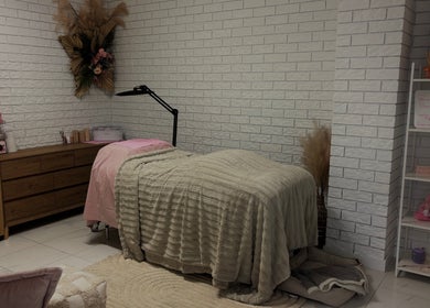 Relaxing treatment room at Elóre Beauty in Lawnton, Queensland, AU, featuring cozy bed and soft lighting.