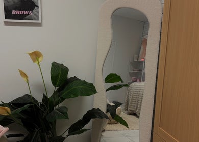 Elóre Beauty's elegant salon with a mirror and plant in Lawnton, Queensland, AU for a serene ambiance.