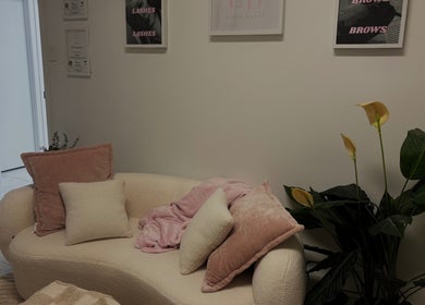 Elegant beige sofa with pink cushions at Elóre Beauty, Lawnton, Queensland, AU, creating a cozy ambiance.