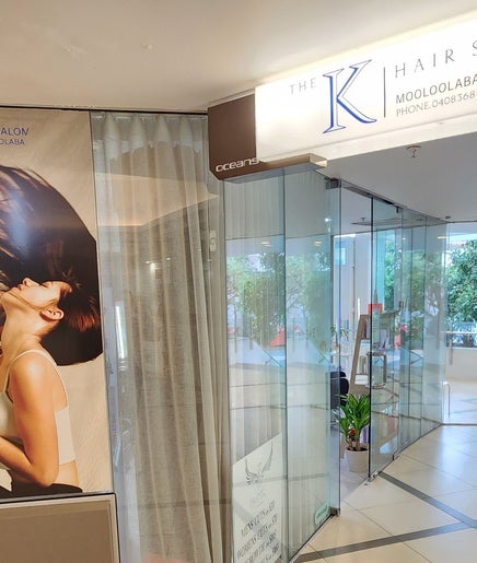 Entrance of THE K HAIR SALON MOOLOOLABA at sunshine coast, Queensland, AU with stylish posters.