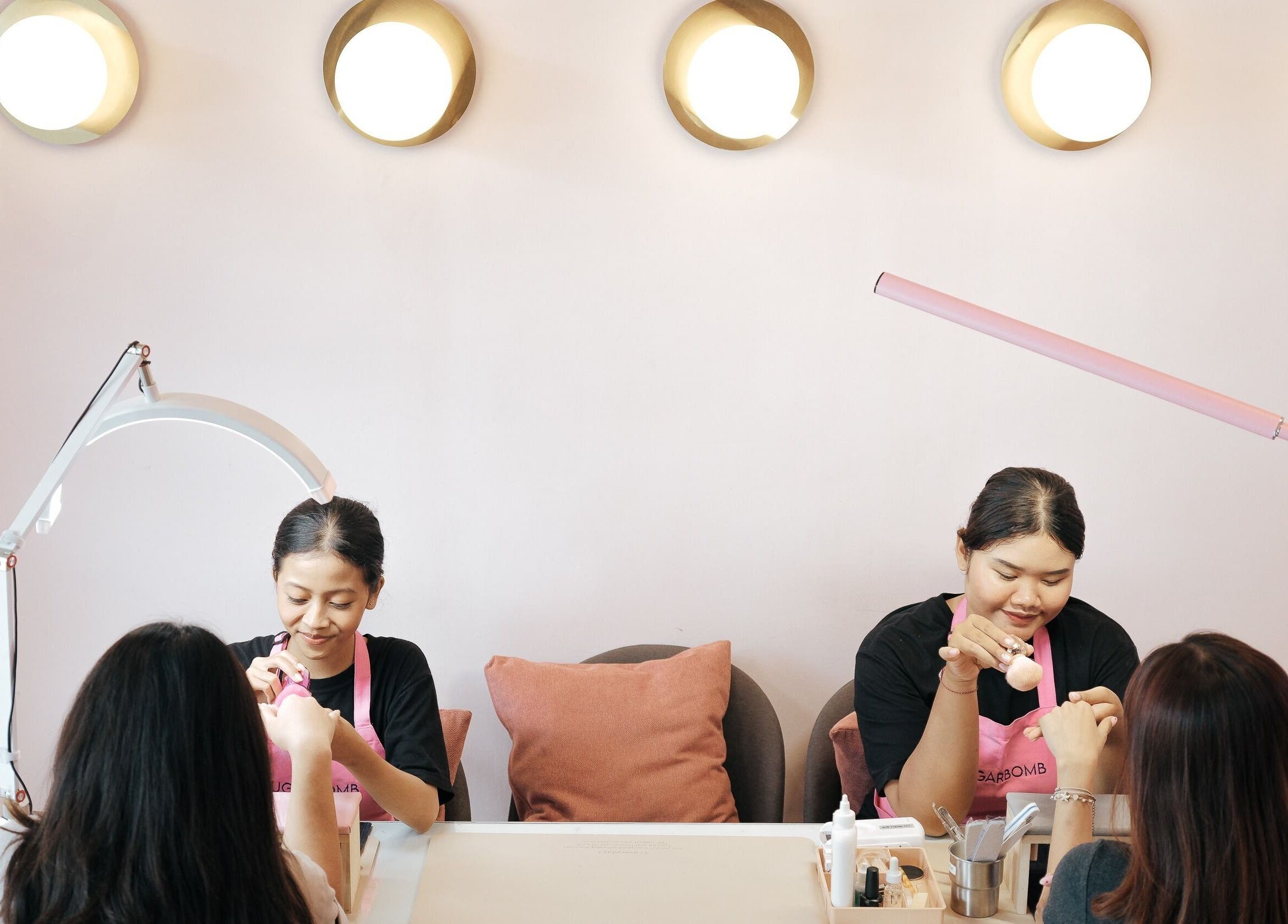 Nail artists at Sugarbombwax Bali offering manicures in a serene setting, Bali, Bali, ID.