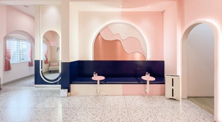 Elegant waiting area in Sugarbombwax Medan, Sumatera Utara, ID with pink and navy decor.