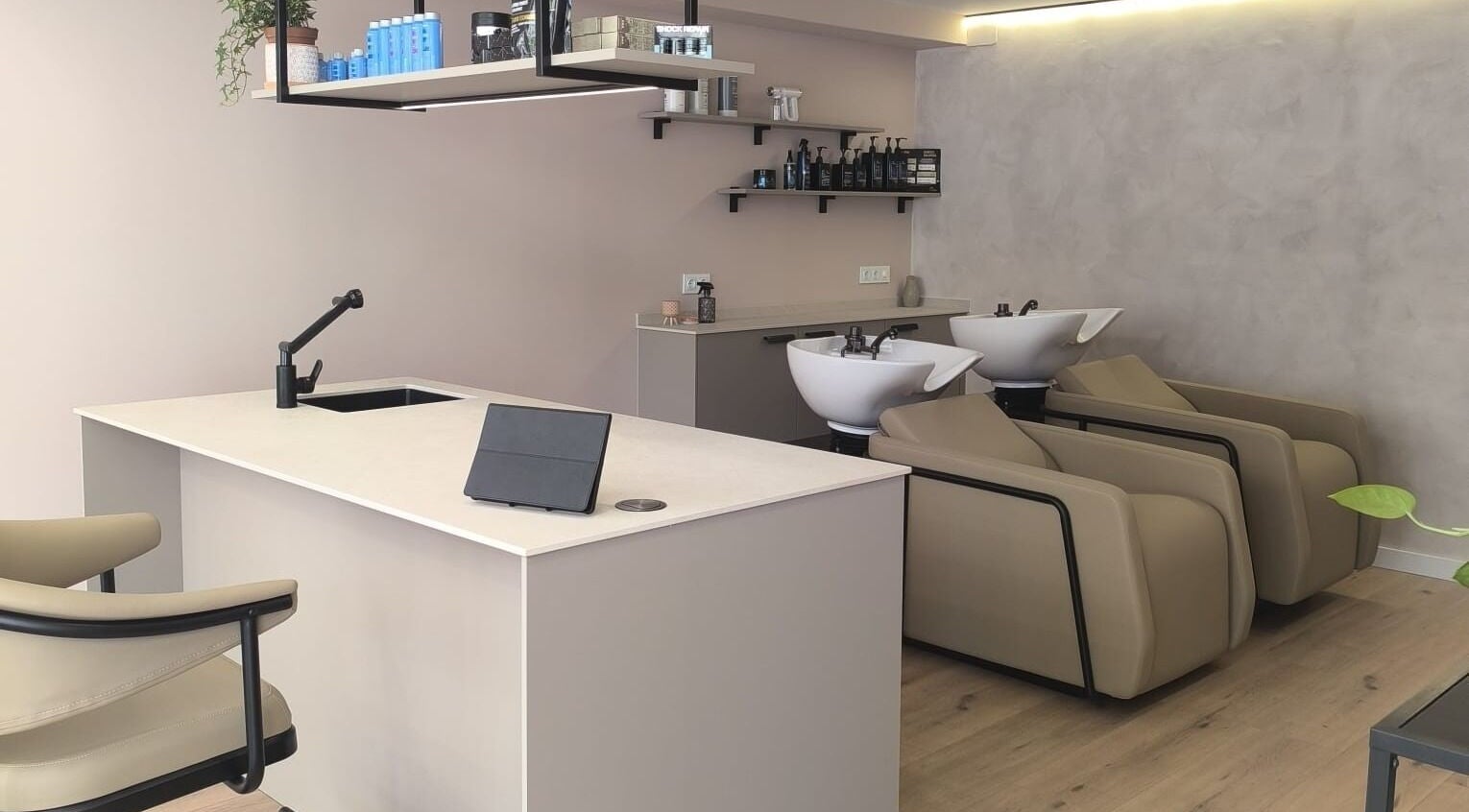 Interior moderno de Mahō Estilistas en Plaja d' Aro, Catalunya, ES con estaciones de lavado y recepción.