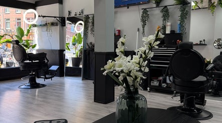 Elegant salon interior at Mourid West, Amsterdam, Noord-Holland, NL with modern decor and stylish barber chair.