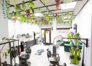 Interior of Mourid West, Amsterdam, Noord-Holland, NL with lush greenery and stylish salon setup.