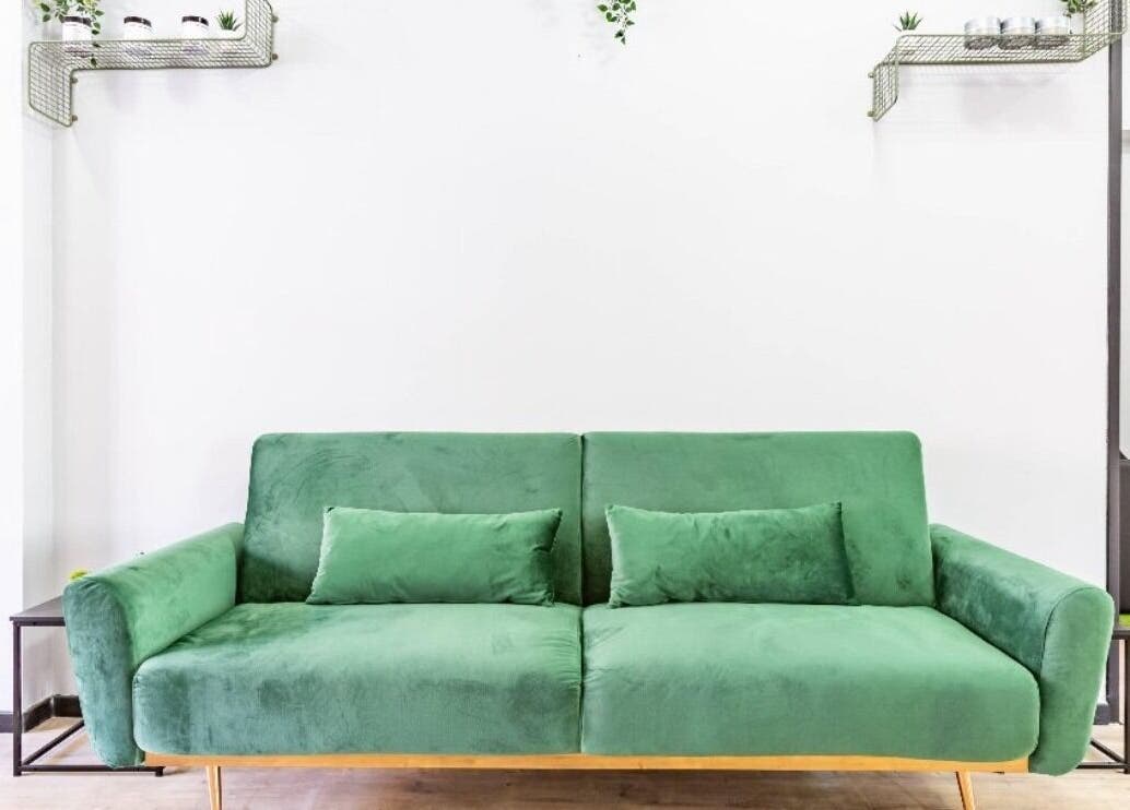 Chic green sofa at Mourid Zuid, Amsterdam, Noord-Holland, NL. Modern decor accents create welcoming ambience.